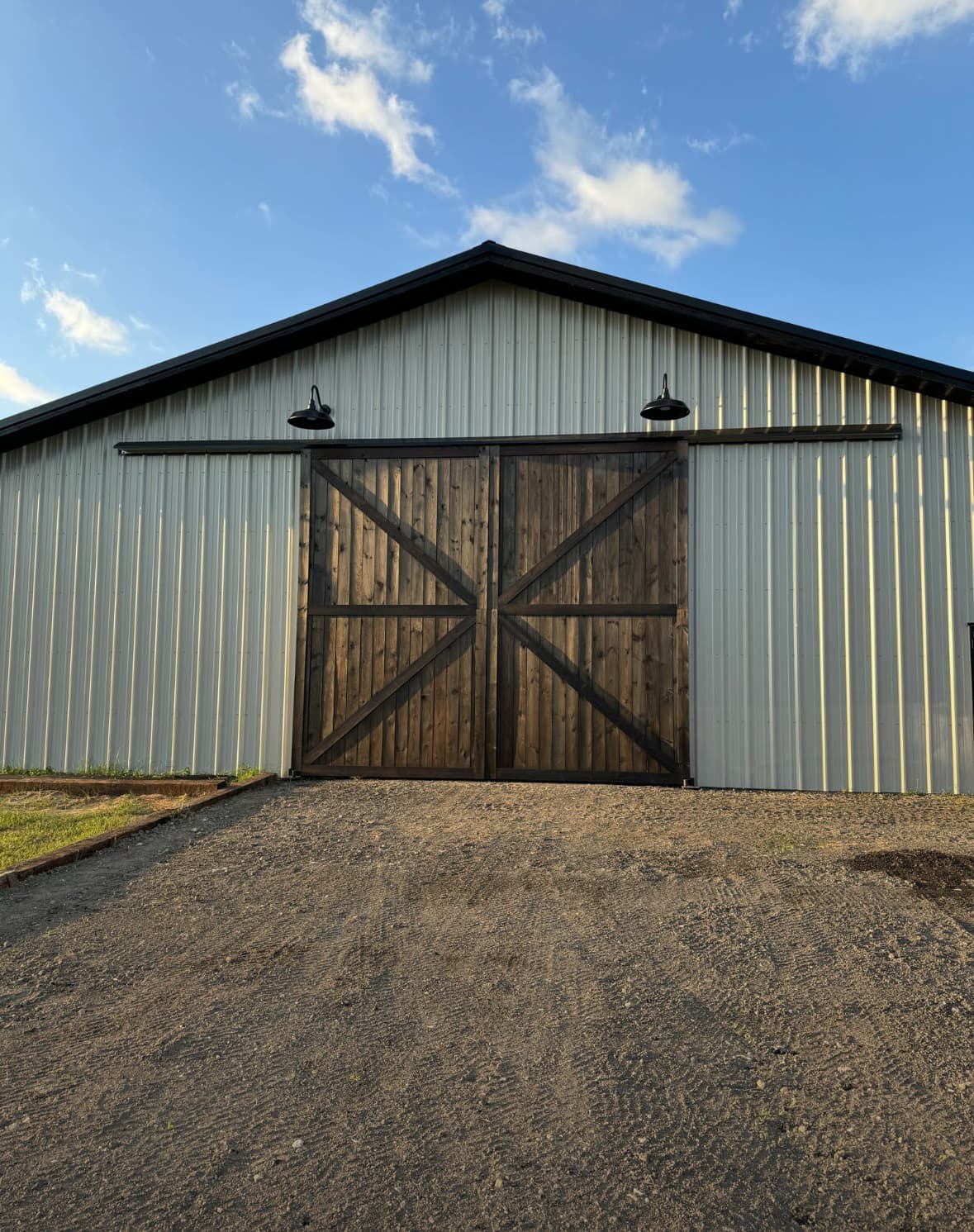 Enclosed pole barn with metal siding and roll-up door